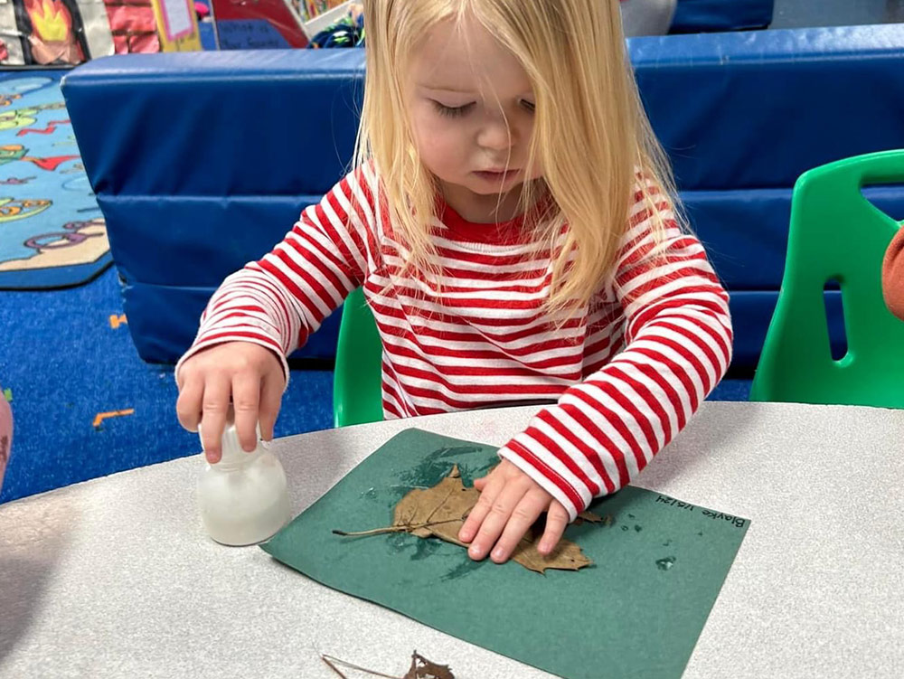 2-Year-Old Room - teacher reading to 2-year-olds at Robins Nest Learning Center