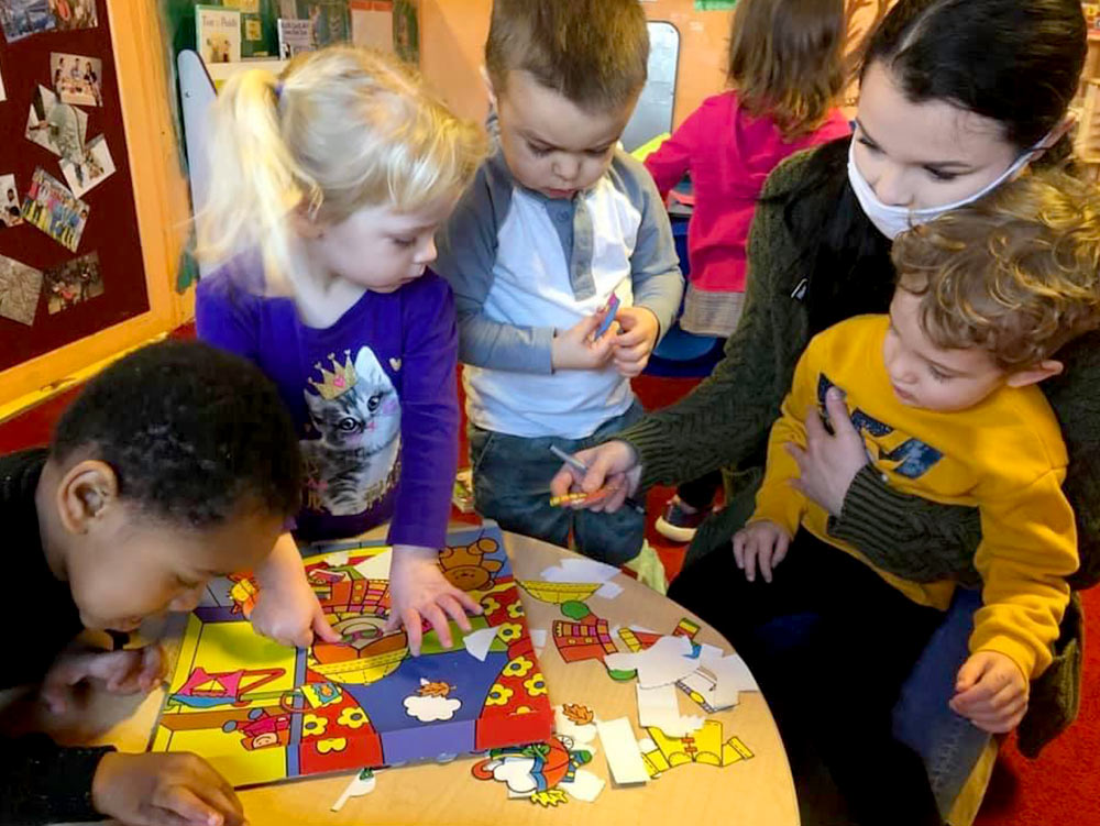 2-Year-Old Room - teacher playing with 2-year-old at Robins Nest Learning Center