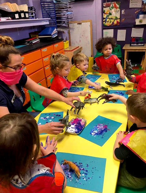2-Year-Old Room - teacher painting with children at Robins Nest Learning Center