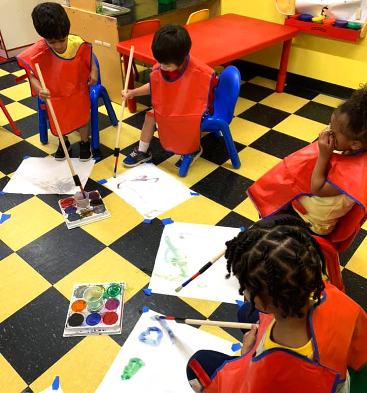 Children painting with large brush at Robin's Nest Learning Center in Carbondale, Illinois