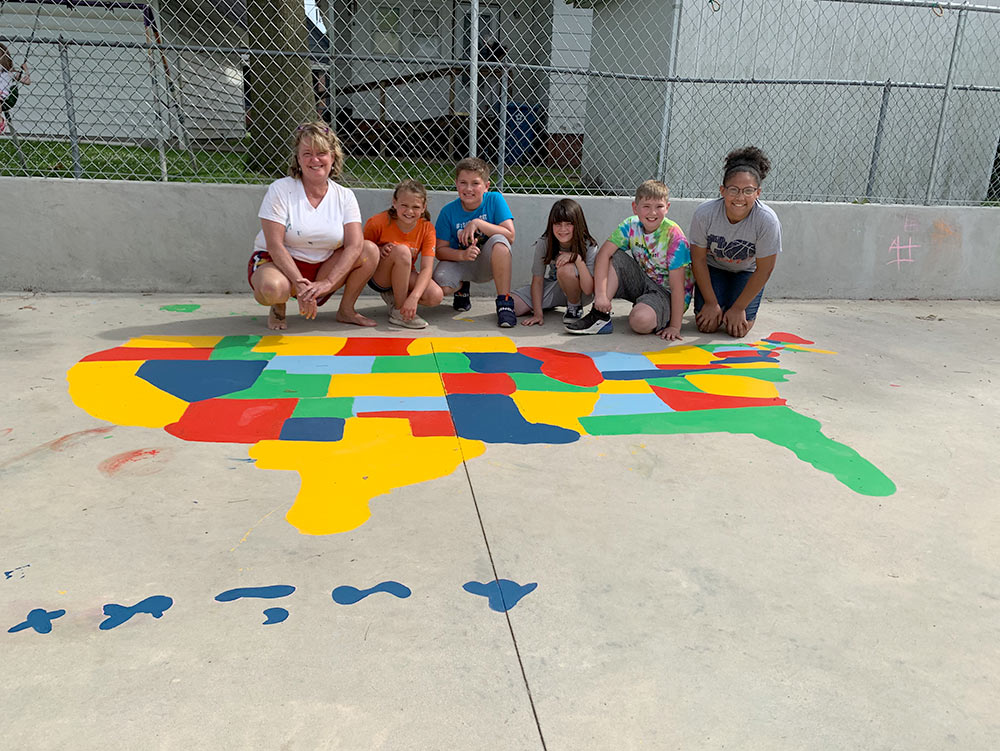 Robin Moore and children with USA map at Robin's Nest Learning Center in Carterville, Illinois