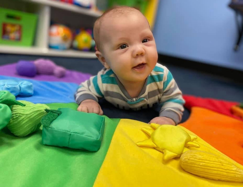 Infant on colorful mat at Robins Nest Learning Center at Robins Nest Learning Center