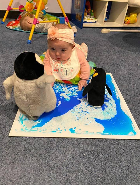 Infant playing with pinguins at Robins Nest Learning Center at Robins Nest Learning Center