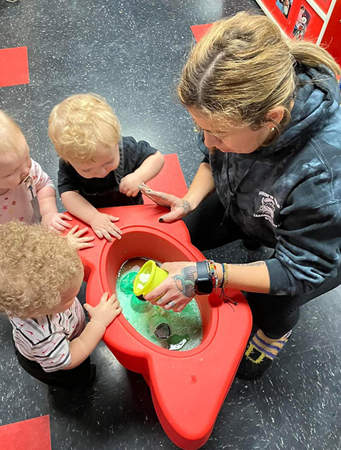 Teacher playing with baby at Robins Nest Learning Center at Robins Nest Learning Center