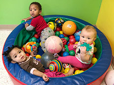The Brown Bear Room - Babies playing with balls at Robins Nest Learning Center